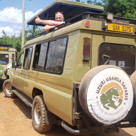 A happy client riding uzuri uganda safari's vehicle going on a gorilla trek